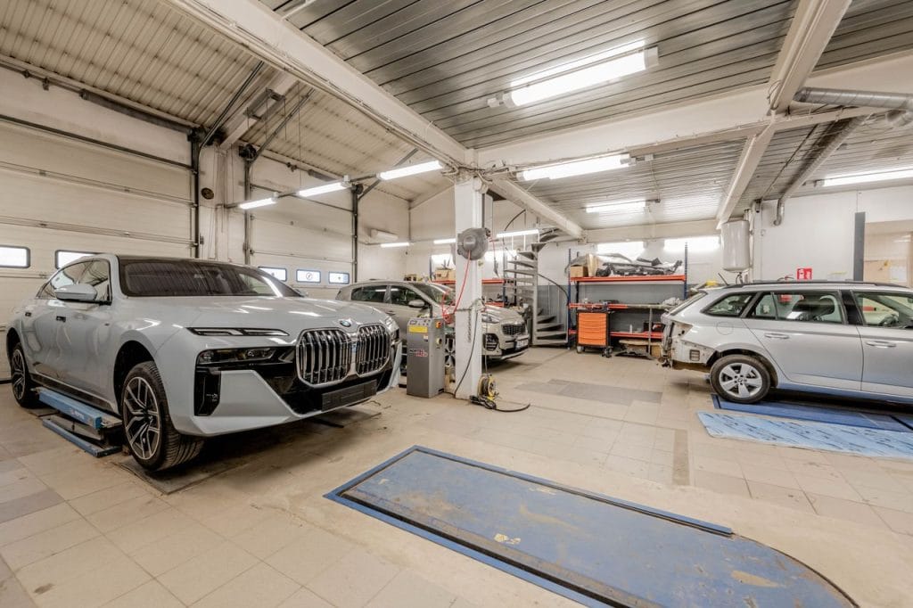 Work Spacious indoor car garage featuring luxury vehicles under maintenance, showcasing an organized and professional workspace.
